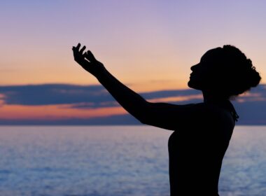 silhouette of woman raising her right hand