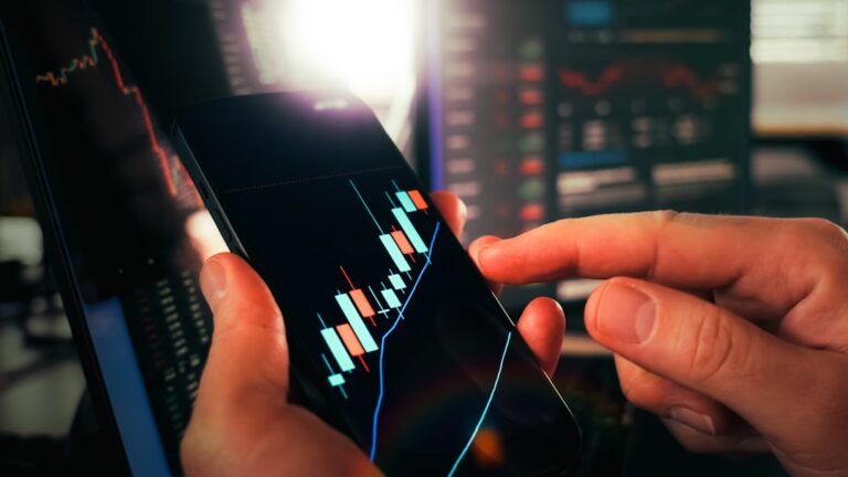 Cryptocurrency trading analysis mobile chart growth candlesticks. Close-up of hands analyzing bullish candlestick patterns on smartphone