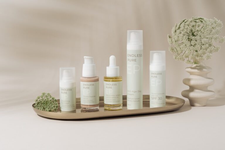 A beautifully arranged display of elegant skincare products on a marble tray against a soft, beige backdrop. The collection includes various bottles and jars, showcasing a range of serums, creams, and SPF protection. The minimalist design and soft pastel colors create a clean, luxurious aesthetic. A delicate floral arrangement in a textured vase adds a natural touch to the composition, enhancing the serene and sophisticated vibe.