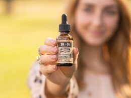 Vrouw houdt een flesje CBD-olie vast